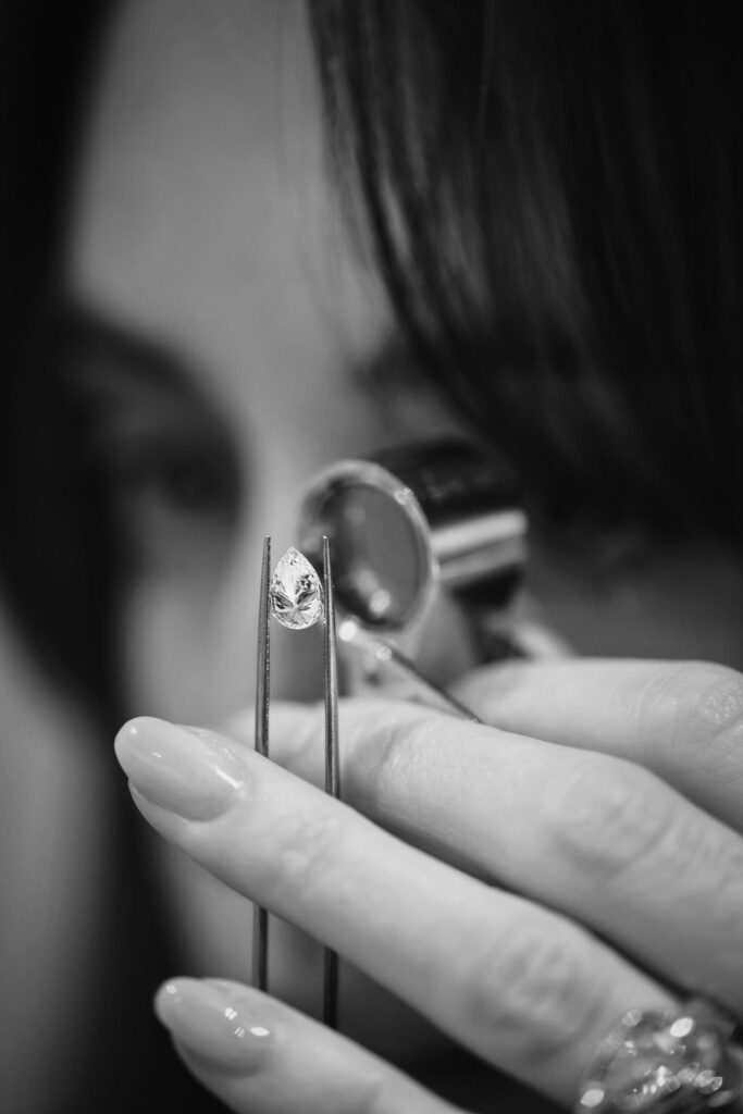 Close-up of a lab-grown diamond held with tweezers during quality inspection, highlighting ethical and sustainable diamond craftsmanship