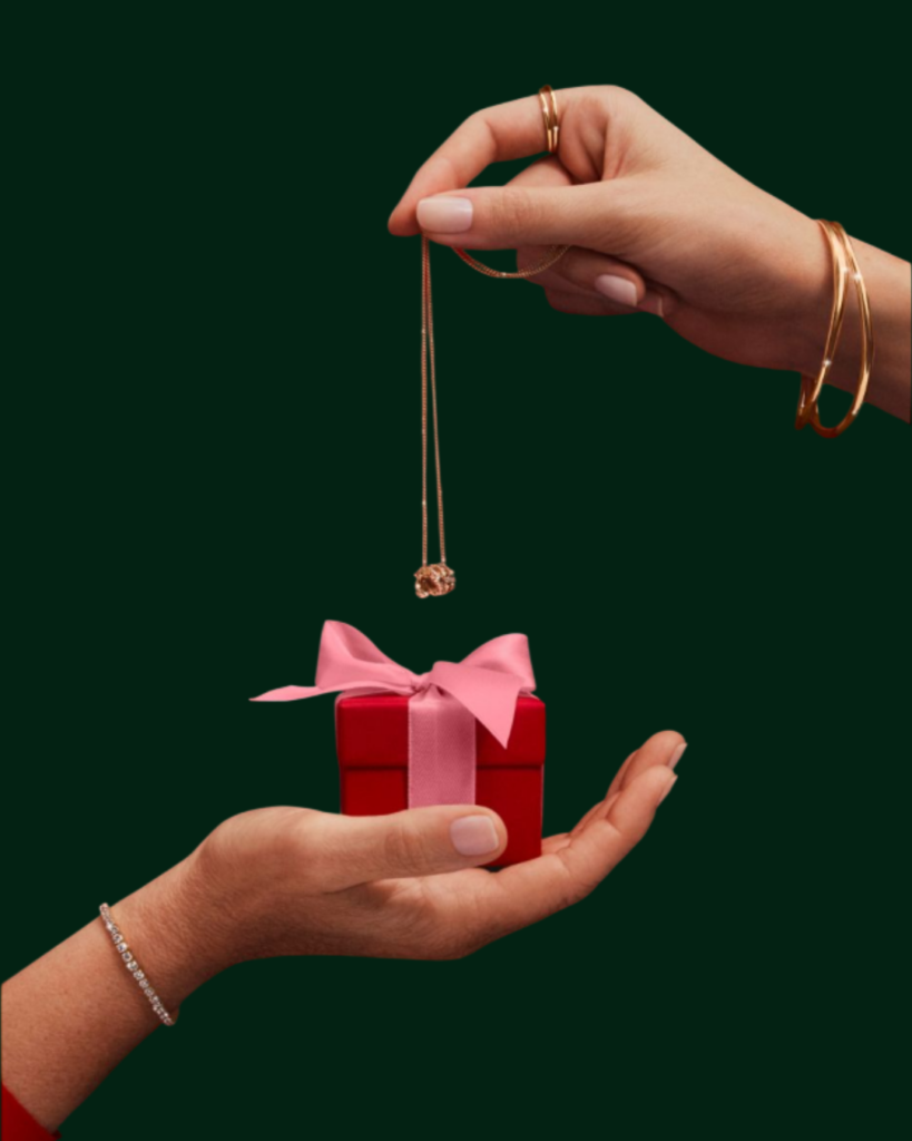 Festive jewelry gifting with a diamond necklace placed over a gift box, symbolizing sustainable and ethical holiday gifting