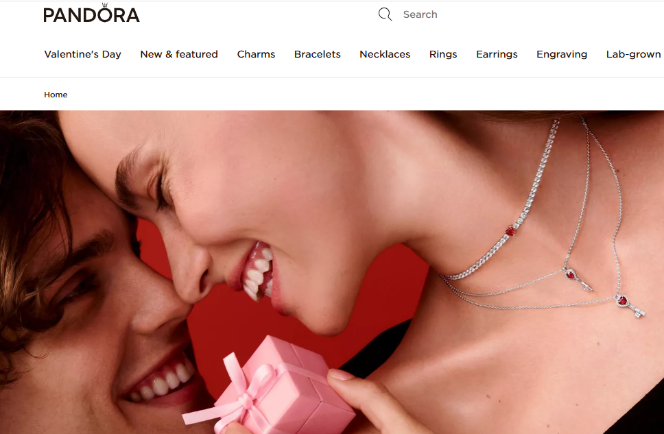 Pandora Valentine’s Day campaign showcasing a couple sharing an intimate moment with heart-inspired jewelry, highlighting branded romance and emotional storytelling.

