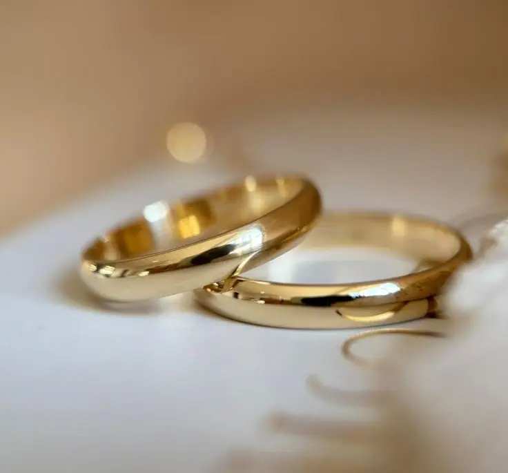 Minimalist gold wedding bands showcasing classic 18K and 22K jewelry options. The Jewelry Gossip bridal guide.

