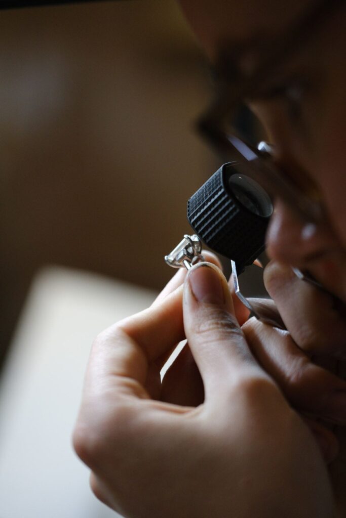 Jewelry quality inspection and hallmark stamp verifying gold purity in manufacturing process.
