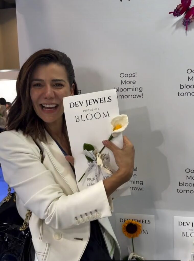  Customer holding crochet flowers at Dev Jewels booth during JCK Las Vegas 2025, showcasing creative gifting and modern jewelry brand presentation